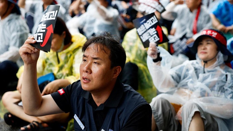 Seorang anggota Serikat Pekerja Logam Korea memegang plakat yang menuntut perpanjangan usia pensiun dan kenaikan harga pasokan komponen dalam sebuah unjuk rasa di luar kantor pusat Hyundai Motor Company, saat serikat pekerja perusahaan otomotif tersebut menggelar pemogokan kerja total pertama dalam satu dekade terakhir, di Seoul, Korea Selatan, pada 21 Agustus 2026.