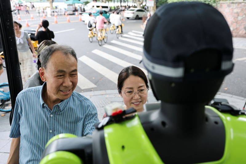 Sebuah robot polisi lalu lintas berbentuk manusia yang dikembangkan oleh SUPCON sedang bertugas di sebuah jalan di Hangzhou, Provinsi Zhejiang, China, pada 21 Juli 2026. (REUTERS/Go Nakamura)