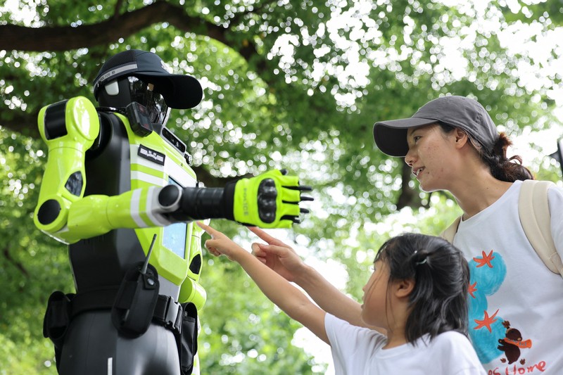 Sebuah robot polisi lalu lintas berbentuk manusia yang dikembangkan oleh SUPCON sedang bertugas di sebuah jalan di Hangzhou, Provinsi Zhejiang, China, pada 21 Juli 2026. (REUTERS/Go Nakamura)