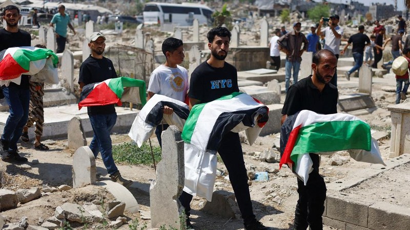 Warga Palestina membawa jenazah saat menghadiri pemakaman 50 orang dari tiga keluarga yang tewas dalam perang dan yang jenazahnya baru-baru ini dievakuasi dari bawah reruntuhan, di Kota Gaza, 20 Agustus 2026.