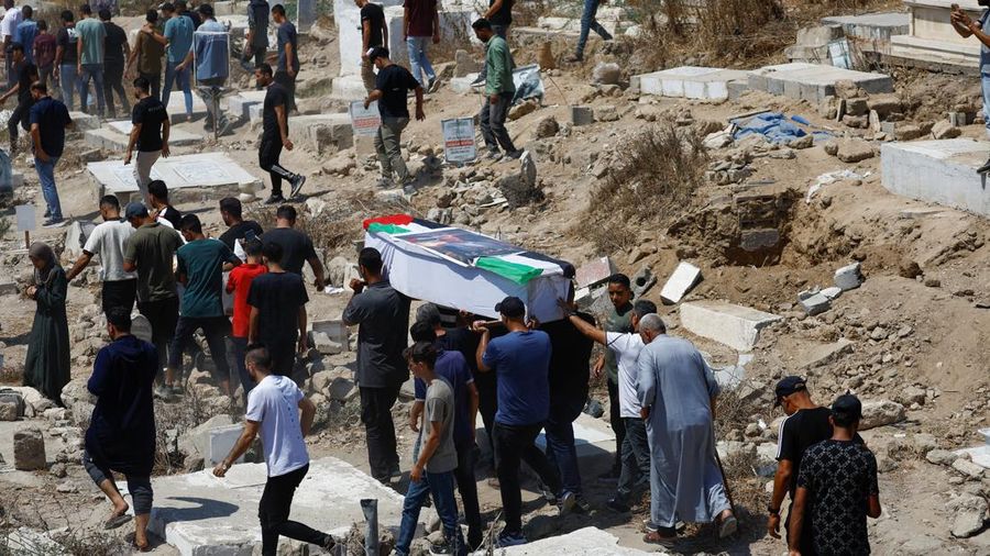Warga Palestina mengusung peti jenazah saat menghadiri pemakaman 50 orang dari tiga keluarga yang tewas dalam perang dan jenazahnya baru-baru ini dievakuasi dari bawah reruntuhan, di Kota Gaza, 20 Agustus 2026. (REUTERS/Mahmoud Issa)