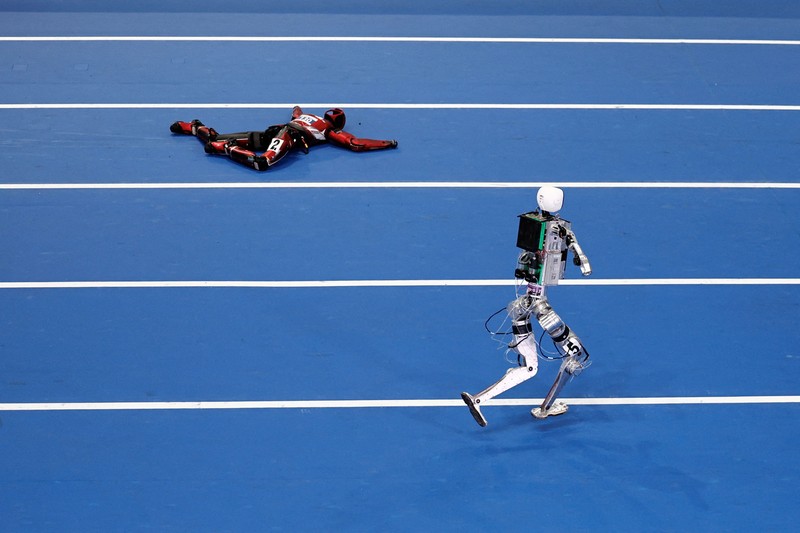 Robot humanoid Honor dan Tiangong bertanding dalam lomba penyisihan kategori kelompok besar jarak 100 meter,etelah upacara pembukaan World Humanoid Robot Games 2026, di National Speed ​​Skating Oval, Beijing, China, Sabtu (22/8/20265). (REUTERS/Tingshu Wang)