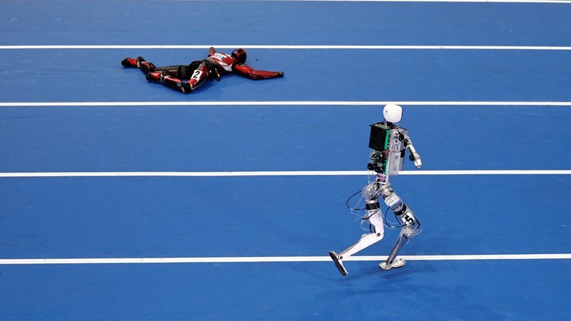 Robot humanoid Honor dan Tiangong bertanding dalam lomba penyisihan kategori kelompok besar jarak 100 meter,etelah upacara pembukaan World Humanoid Robot Games 2026, di National Speed ​​Skating Oval, Beijing, China, Sabtu (22/8/20265). (REUTERS/Tingshu Wang)