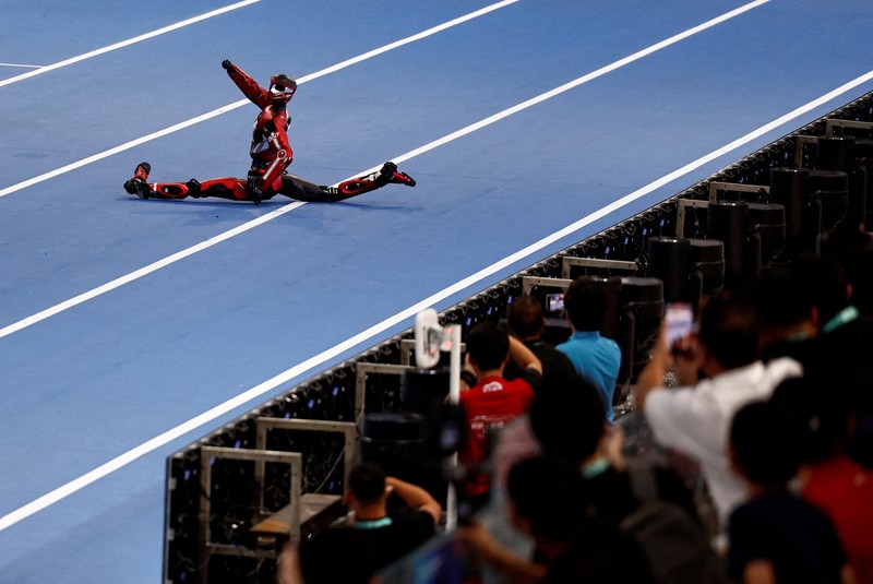 Robot humanoid Honor dan Tiangong bertanding dalam lomba penyisihan kategori kelompok besar jarak 100 meter,etelah upacara pembukaan World Humanoid Robot Games 2026, di National Speed ​​Skating Oval, Beijing, China, Sabtu (22/8/20265). (REUTERS/Tingshu Wang)
