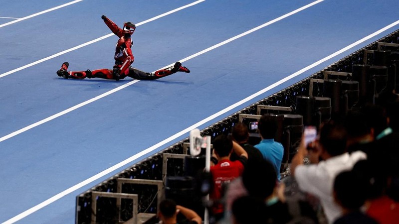 Robot humanoid Honor dan Tiangong bertanding dalam lomba penyisihan kategori kelompok besar jarak 100 meter,etelah upacara pembukaan World Humanoid Robot Games 2026, di National Speed ​​Skating Oval, Beijing, China, Sabtu (22/8/20265). (REUTERS/Tingshu Wang)