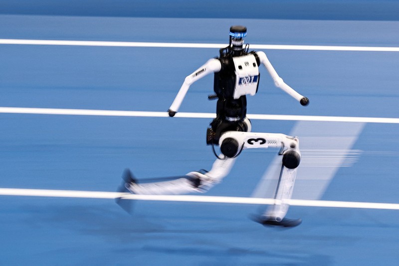Robot humanoid Honor dan Tiangong bertanding dalam lomba penyisihan kategori kelompok besar jarak 100 meter,etelah upacara pembukaan World Humanoid Robot Games 2026, di National Speed ​​Skating Oval, Beijing, China, Sabtu (22/8/20265). (REUTERS/Tingshu Wang)