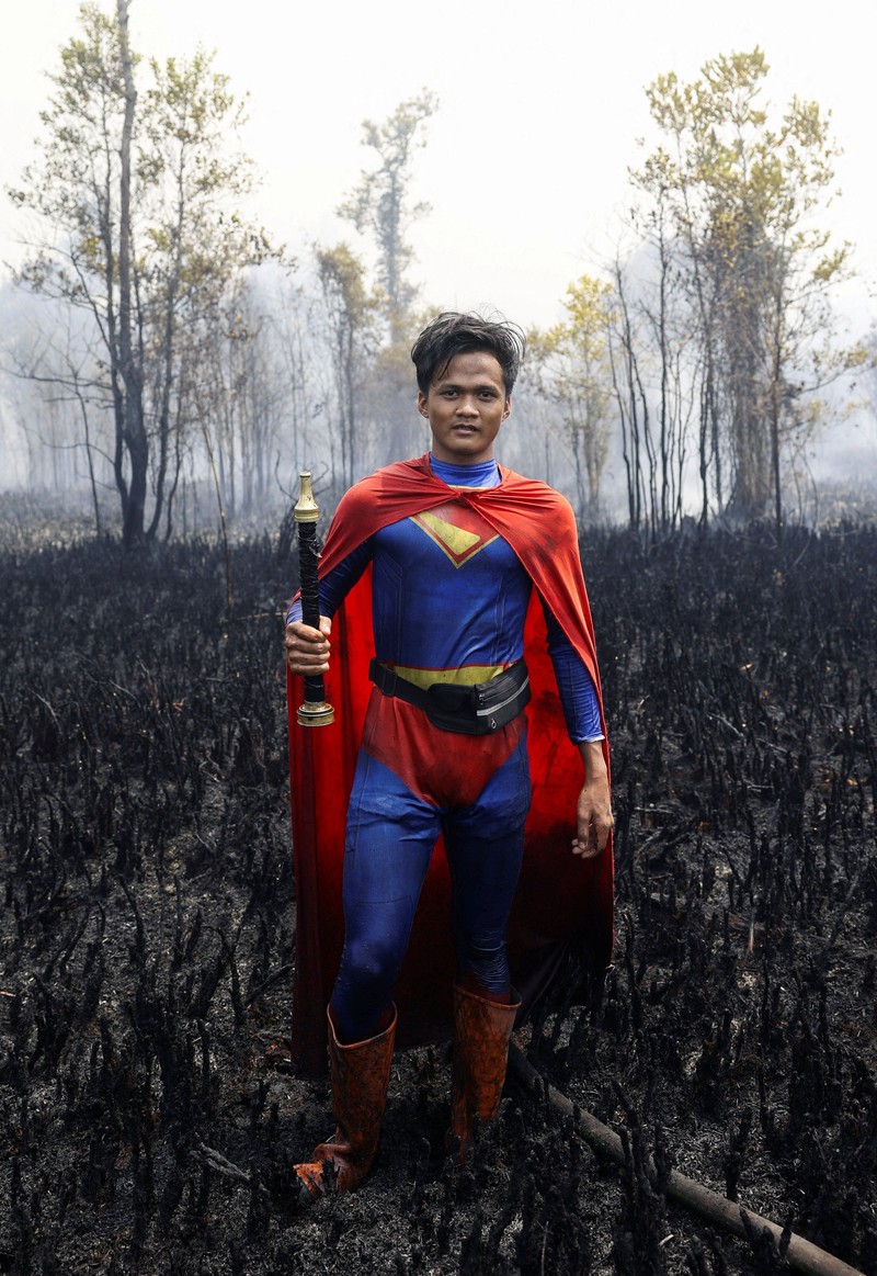 Rudiyansah, 16 tahun, mengenakan kostum Superman saat memadamkan api di area yang terdampak kebakaran hutan dan lahan di Palangka Raya, Provinsi Kalimantan Tengah, Jumat (14/8/2026). (REUTERS/Ajeng Dinar Ulfiana)