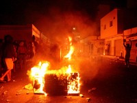 Api berkobar di jalan saat para pengunjuk rasa bentrok dengan aparat keamanan dalam sebuah aksi protes, menyusul tenggelamnya kapal migran yang menuju Italia, di Ben Guerdane, Tunisia, 24 Agustus 2026. (REUTERS/Ahmed Jarray)