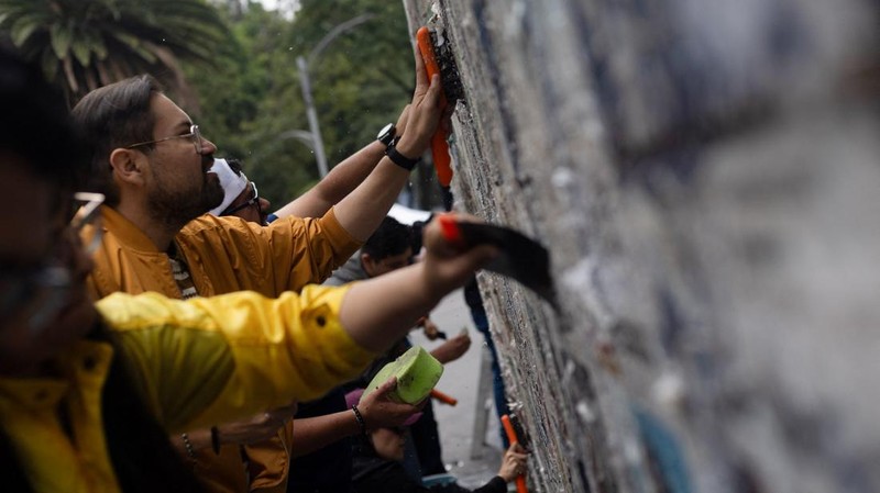 Keluarga dan kelompok pencari membersihkan pagar di Bundaran Ahuehuete—yang secara tidak resmi dinamai ulang oleh para aktivis sebagai