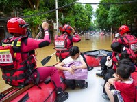 Rescue workers evacuate flood-affected residents by boat after heavy rainfall brought by typhoon Narra caused flooding in Longzhou county, Chongzuo, Guangxi Zhuang Autonomous Region, China August 24, 2026. cnsphoto via REUTERS   ATTENTION EDITORS - T