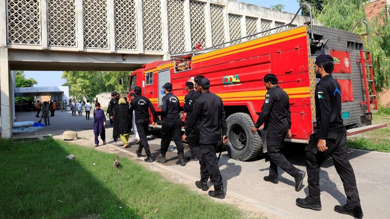Anggota Pasukan Anti-Teror melintas di dekat mobil pemadam kebakaran setelah kebakaran mematikan di rumah sakit Pakistan Institute of Medical Sciences (PIMS) di Islamabad, Pakistan, pada 26 Agustus 2026.