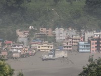 Bangunan-bangunan yang terendam sebagian di sepanjang tepi sungai akibat banjir bandang di distrik Nuwakot, Nepal, pada 26 Agustus 2026, sebagaimana terlihat dalam tangkapan layar dari video yang dirilis untuk umum. (Sujan Bagale/Handout via REUTERS)
