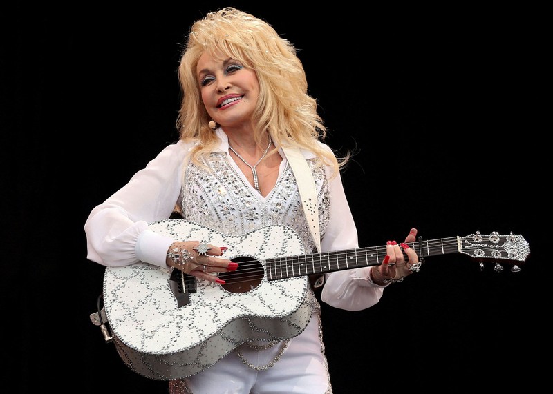 Pembawa acara Dolly Parton mengajak bintang-bintang lain untuk bergabung dengannya saat ia membawakan lagu *country* 10 Oktober 1988. (Callie Shell/USA Today Network via REUTERS)