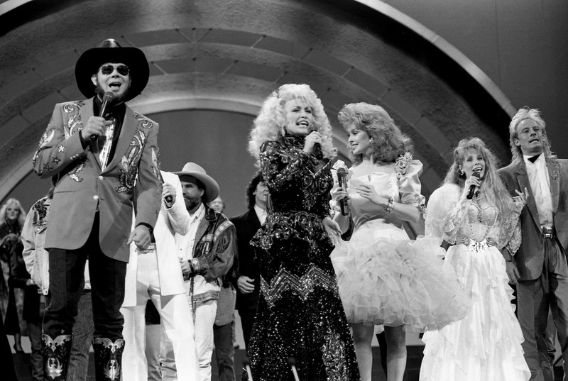 Pembawa acara Dolly Parton mengajak bintang-bintang lain untuk bergabung dengannya saat ia membawakan lagu *country* 10 Oktober 1988. (Callie Shell/USA Today Network via REUTERS)