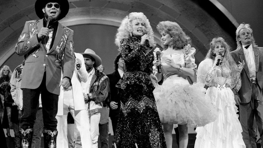 Pembawa acara Dolly Parton mengajak bintang-bintang lain untuk bergabung dengannya saat ia membawakan lagu *country* 10 Oktober 1988. (Callie Shell/USA Today Network via REUTERS)