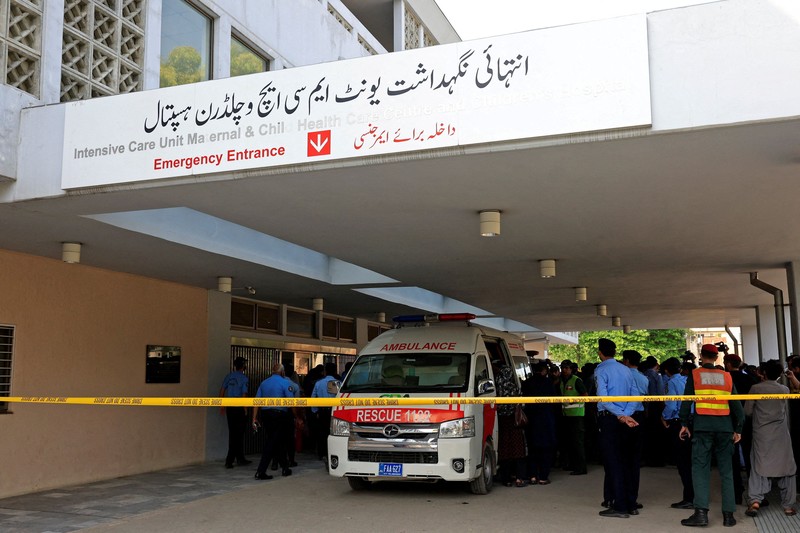 Petugas kepolisian melintas di dekat ambulans di luar unit perawatan intensif setelah kebakaran terjadi di rumah sakit Pakistan Institute of Medical Sciences (PIMS) di Islamabad, Pakistan, 26 Agustus 2026. (REUTERS/Akhtar Soomro)