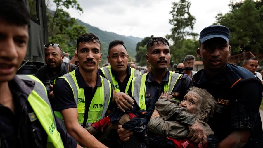Petugas kepolisian membawa seorang korban selamat ke tempat yang lebih aman setelah banjir bandang di Trishuli, distrik Nuwakot, Nepal, pada 26 Agustus 2026.