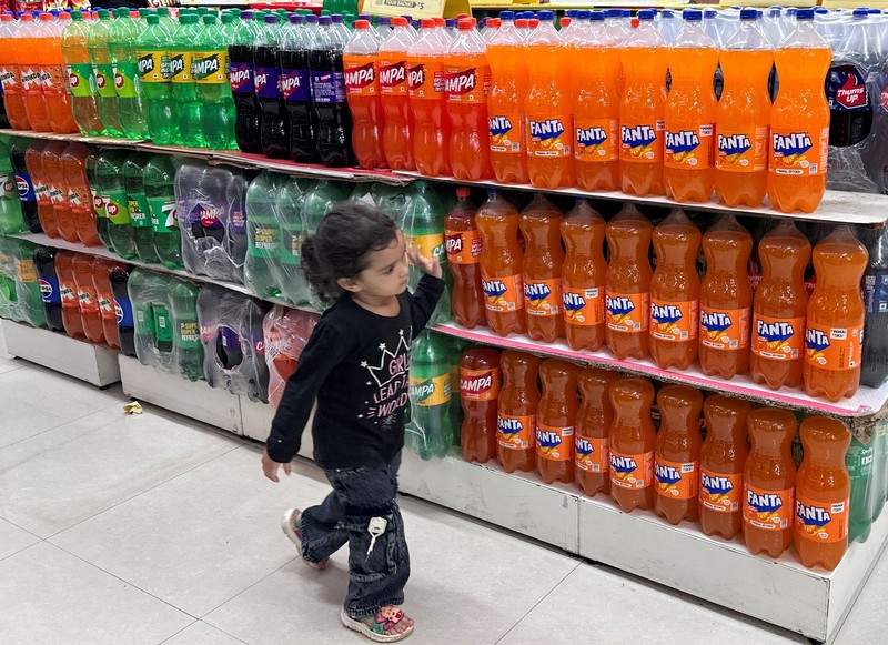 Seorang anak berjalan melewati deretan botol minuman ringan di dalam sebuah supermarket di Mumbai, India, pada 19 Agustus 2026. Foto diambil menggunakan ponsel. (REUTERS/Francis Mascarenhas)