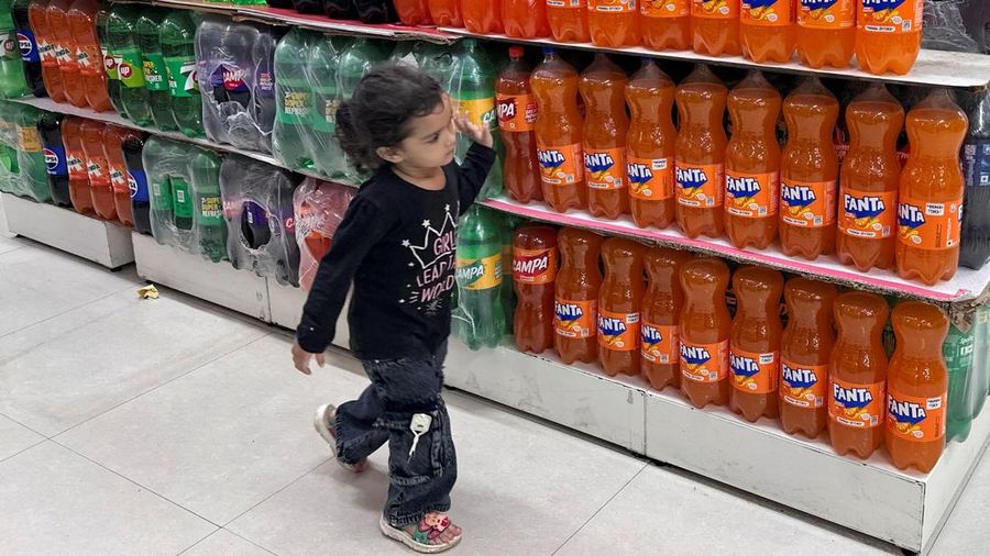 Seorang anak berjalan melewati deretan botol minuman ringan di dalam sebuah supermarket di Mumbai, India, pada 19 Agustus 2026. Foto diambil menggunakan ponsel. (REUTERS/Francis Mascarenhas)