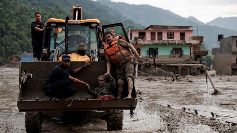 Seorang penyintas dibawa ke tempat yang lebih aman menggunakan alat berat JCB setelah banjir bandang di Trishuli, distrik Nuwakot, Nepal, pada 26 Agustus 2026.