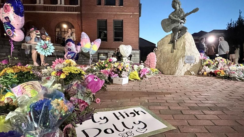 Warga memberikan penghormatan kepada Dolly Parton setelah pengumuman wafatnya, di lokasi patung Dolly Parton di pusat kota Sevierville, Tennessee, AS, pada 25 Agustus 2026. (REUTERS/Kevin Fogarty)