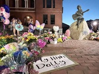 Warga memberikan penghormatan kepada Dolly Parton setelah pengumuman wafatnya, di lokasi patung Dolly Parton di pusat kota Sevierville, Tennessee, AS, pada 25 Agustus 2026. (REUTERS/Kevin Fogarty)