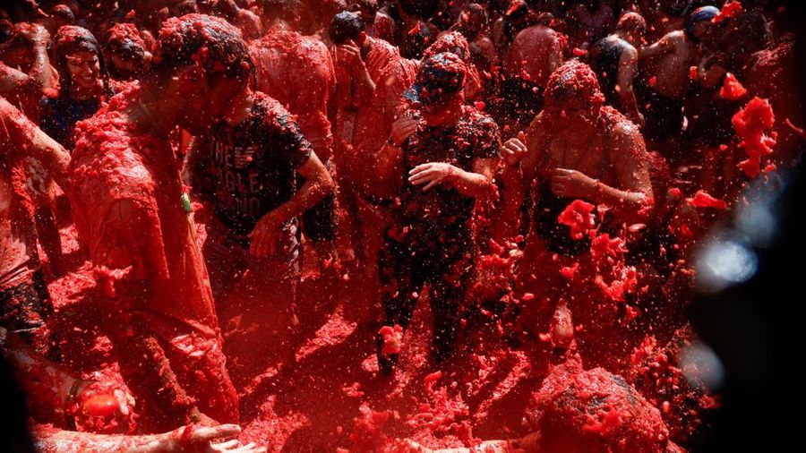 Para peserta bersenang-senang di tengah bubur tomat dalam festival perang makanan tahunan "La Tomatina" di Bunol, Spanyol, pada 26 Agustus 2026. (REUTERS/Thomas Peter)