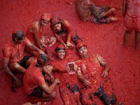 Para peserta bersenang-senang di tengah bubur tomat dalam festival perang makanan tahunan "La Tomatina" di Bunol, Spanyol, pada 26 Agustus 2026. (REUTERS/Thomas Peter)