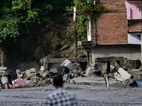 Seorang pria yang membawa barang-barangnya berjalan melintasi puing-puing pascabanjir dahsyat di Trishuli, Distrik Nuwakot, Nepal, pada 27 Agustus 2026. (REUTERS/Navesh Chitrakar)