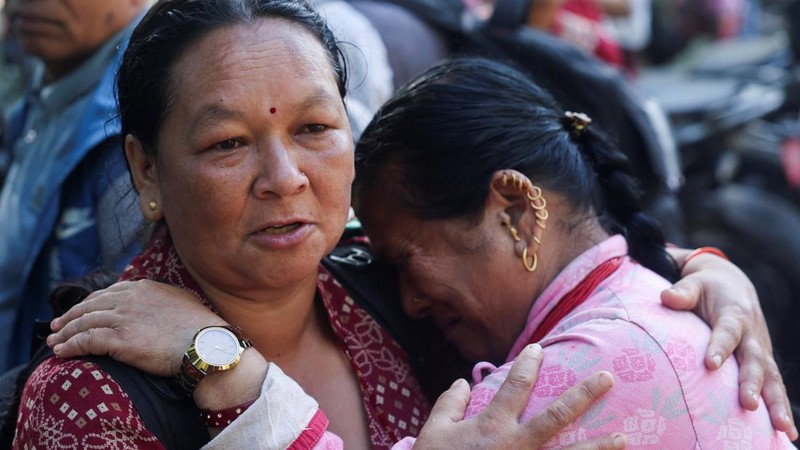 Kalpana Rimal, yang berjalan kaki dari distrik Rasuwa, menghibur seorang wanita yang rumahnya juga terdampak banjir bandang dan tanah longsor, di luar pusat pelatihan militer Maithali Barrack di Nuwakot, Nepal, pada 28 Agustus 2026.