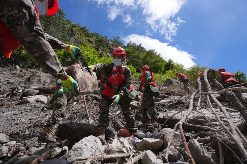 Warga melihat foto-foto korban tewas akibat banjir dan tanah longsor yang ditempel di gerbang untuk keperluan identifikasi di luar kamar jenazah di Kathmandu, Nepal, pada 27 Agustus 2026. (REUTERS/Sabrina Dangol)