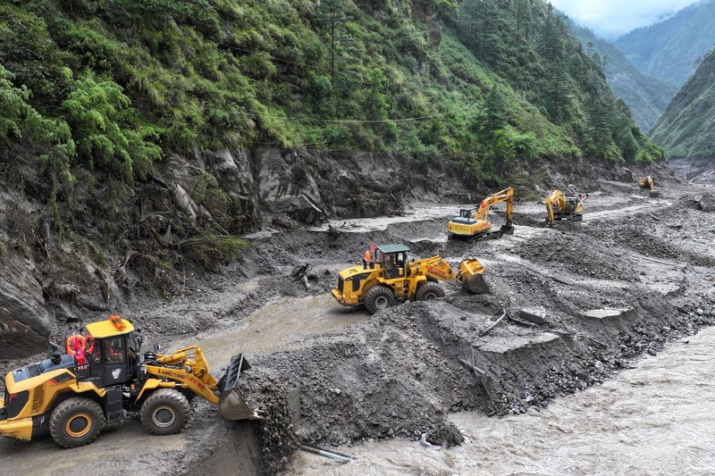 Warga melihat foto-foto korban tewas akibat banjir dan tanah longsor yang ditempel di gerbang untuk keperluan identifikasi di luar kamar jenazah di Kathmandu, Nepal, pada 27 Agustus 2026. (REUTERS/Sabrina Dangol)