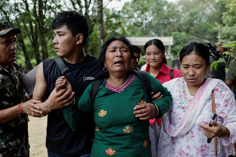 Seorang perempuan yang terdampak banjir bandang dan tanah longsor tiba di Barak Maithali, sebuah pusat pelatihan militer, di Trishuli, Distrik Nuwakot, Nepal, pada 28 Agustus 2026. (REUTERS/Navesh Chitrakar)