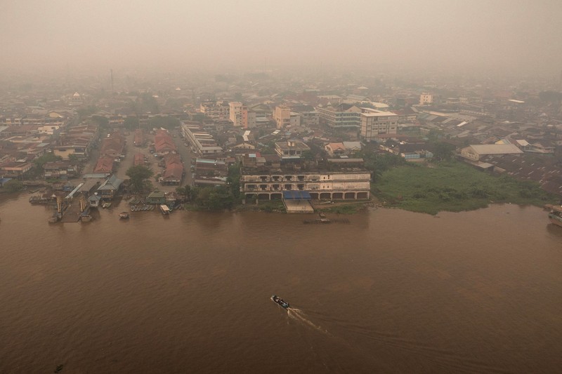 Tampilan dari drone yang memperlihatkan kapal-kapal di Sungai Kapuas saat kabut asap akibat kebakaran hutan menyelimuti wilayah tersebut di Pontianak, Provinsi Kalimantan Barat, Indonesia, pada 27 Agustus 2026. (REUTERS/Willy Kurniawan)
