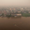 Tampilan dari drone memperlihatkan orang-orang menaiki perahu kayu menyeberangi Sungai Kapuas saat kabut asap akibat kebakaran hutan menyelimuti wilayah tersebut di Pontianak, Provinsi Kalimantan Barat, Indonesia, pada 27 Agustus 2026.(REUTERS/Willy