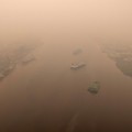 Tampilan dari drone yang memperlihatkan kapal-kapal di Sungai Kapuas saat kabut asap akibat kebakaran hutan menyelimuti wilayah tersebut di Pontianak, Provinsi Kalimantan Barat, Indonesia, pada 27 Agustus 2026. (REUTERS/Willy Kurniawan)