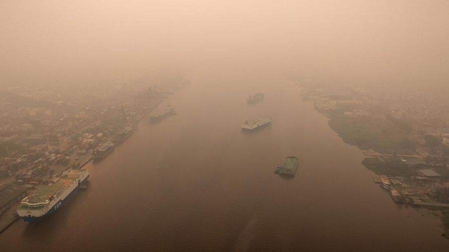 Tampilan dari drone yang memperlihatkan kapal-kapal di Sungai Kapuas saat kabut asap akibat kebakaran hutan menyelimuti wilayah tersebut di Pontianak, Provinsi Kalimantan Barat, Indonesia, pada 27 Agustus 2026. (REUTERS/Willy Kurniawan)