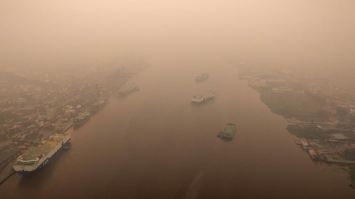 Tampilan dari drone yang memperlihatkan kapal-kapal di Sungai Kapuas saat kabut asap akibat kebakaran hutan menyelimuti wilayah tersebut di Pontianak, Provinsi Kalimantan Barat, Indonesia, pada 27 Agustus 2026. (REUTERS/Willy Kurniawan)