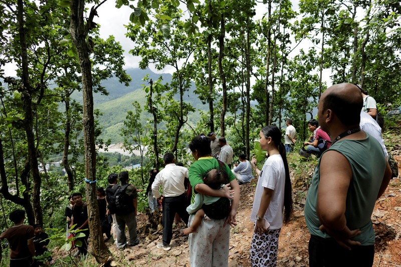 Seorang perempuan yang terdampak banjir bandang dan tanah longsor tiba di Barak Maithali, sebuah pusat pelatihan militer, di Trishuli, Distrik Nuwakot, Nepal, pada 28 Agustus 2026. (REUTERS/Navesh Chitrakar)