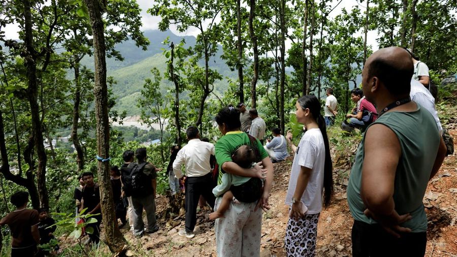 Warga berdiri di atas bukit setelah mencapai dataran tinggi menyusul peringatan bahwa tanggul danau telah jebol, dua hari setelah banjir bandang dan tanah longsor di Trishuli, distrik Nuwakot, Nepal, pada 28 Agustus 2026.