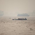 Warga menaiki perahu kayu melintasi Sungai Kapuas saat kabut asap akibat kebakaran hutan menyelimuti wilayah tersebut di Pontianak, Provinsi Kalimantan Barat, Indonesia, pada 27 Agustus 2026. (REUTERS/Willy Kurniawan)
