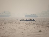 Warga menaiki perahu kayu melintasi Sungai Kapuas saat kabut asap akibat kebakaran hutan menyelimuti wilayah tersebut di Pontianak, Provinsi Kalimantan Barat, Indonesia, pada 27 Agustus 2026. (REUTERS/Willy Kurniawan)