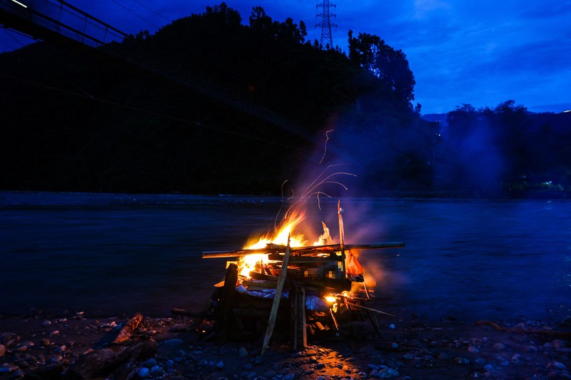 Kerabat Prabita Roila (32 tahun)&mdash;yang meninggal dunia akibat banjir bandang dan tanah longsor mematikan&mdash;bersiap menyalakan api pembakaran jenazah di Sungai Suryamati, Trishuli, Distrik Nuwakot, Nepal, pada 30 Agustus 2026. (REUTERS/Athit Perawongmetha)