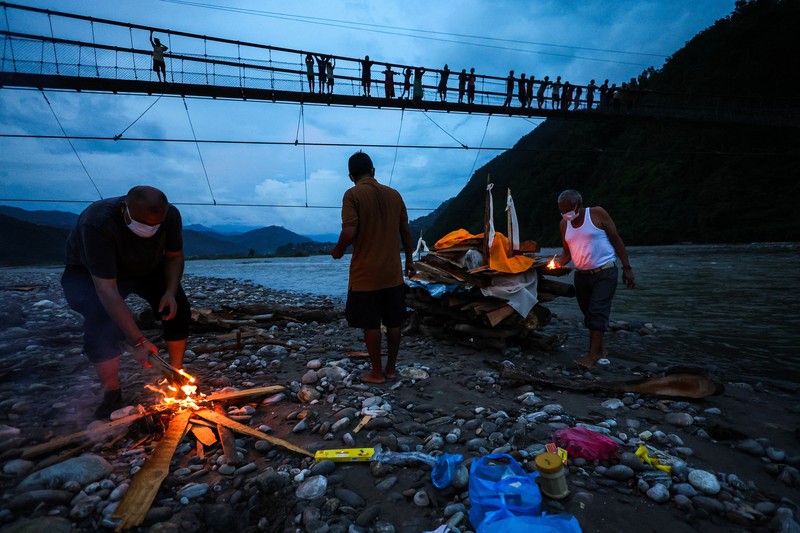 Kerabat Prabita Roila (32 tahun)&mdash;yang meninggal dunia akibat banjir bandang dan tanah longsor mematikan&mdash;bersiap menyalakan api pembakaran jenazah di Sungai Suryamati, Trishuli, Distrik Nuwakot, Nepal, pada 30 Agustus 2026. (REUTERS/Athit Perawongmetha)