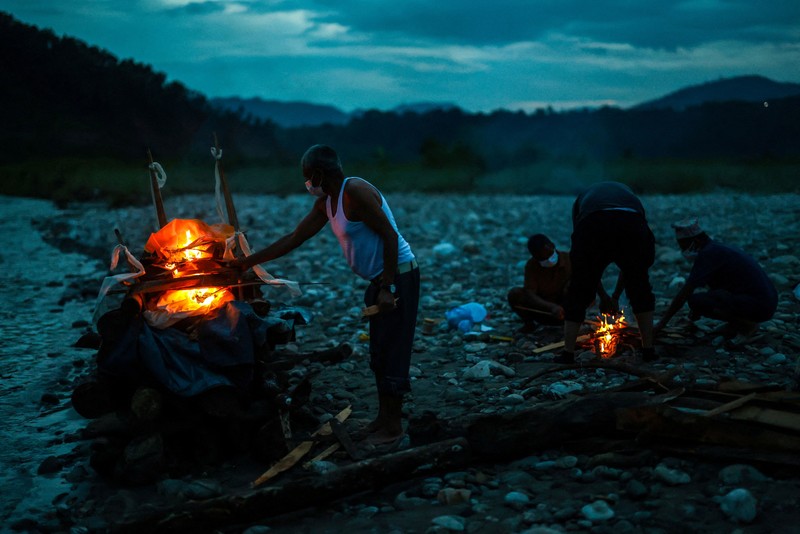 Kerabat Prabita Roila (32 tahun)&mdash;yang meninggal dunia akibat banjir bandang dan tanah longsor mematikan&mdash;bersiap menyalakan api pembakaran jenazah di Sungai Suryamati, Trishuli, Distrik Nuwakot, Nepal, pada 30 Agustus 2026. (REUTERS/Athit Perawongmetha)