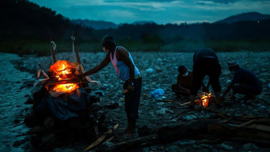 Kerabat Prabita Roila (32 tahun)—yang meninggal dunia akibat banjir bandang dan tanah longsor mematikan—menyalakan api pembakaran jenazahnya di Sungai Suryamati di Trishuli, Distrik Nuwakot, Nepal, pada 30 Agustus 2026.