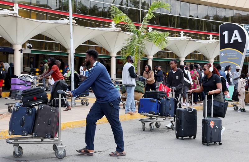 Para pelancong berjalan membawa bagasi mereka setelah operasional penerbangan terganggu akibat aksi mogok kerja karyawan di Bandara Internasional Jomo Kenyatta (JKIA) di Nairobi, Kenya, pada 30 Agustus 2026. (REUTERS/Monicah Mwangi)