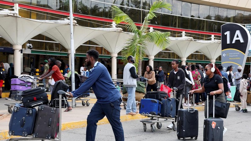 Para pelancong berjalan membawa bagasi mereka setelah operasional penerbangan terganggu akibat aksi mogok kerja karyawan di Bandara Internasional Jomo Kenyatta (JKIA) di Nairobi, Kenya, pada 30 Agustus 2026. (REUTERS/Monicah Mwangi)