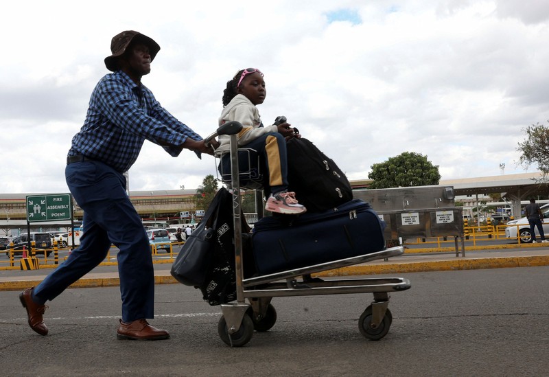 Para pelancong berjalan membawa bagasi mereka setelah operasional penerbangan terganggu akibat aksi mogok kerja karyawan di Bandara Internasional Jomo Kenyatta (JKIA) di Nairobi, Kenya, pada 30 Agustus 2026. (REUTERS/Monicah Mwangi)