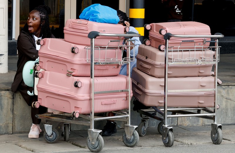 Para pelancong berjalan membawa bagasi mereka setelah operasional penerbangan terganggu akibat aksi mogok kerja karyawan di Bandara Internasional Jomo Kenyatta (JKIA) di Nairobi, Kenya, pada 30 Agustus 2026. (REUTERS/Monicah Mwangi)